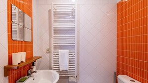 A bathroom with a white sink, a mirror, and a towel rack.