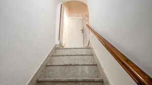 A staircase with stone steps and a wooden handrail leading to a door. - GuestHost - Casa Vita 51 in Ceglie Messapica (Ceglie Messapica)