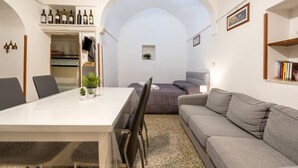 A compact living space with a dining table, sofa, and a small window. - GuestHost - Casa Vita 51 in Ceglie Messapica (Ceglie Messapica)