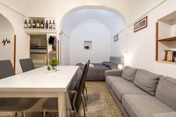 Un espace de vie compact comprenant une table à manger, un canapé et une petite fenêtre.