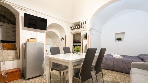 A compact living space with a dining area, kitchenette, and seating area. - GuestHost - Casa Vita 51 in Ceglie Messapica (Ceglie Messapica)