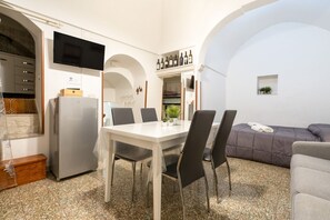 Un espace de vie compact comprenant un coin repas, une kitchenette et un coin salon.