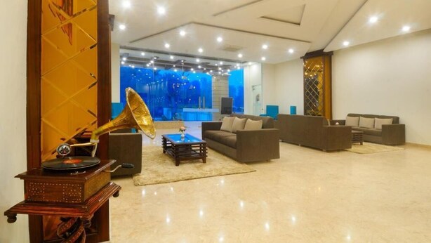 Ampla sala de estar com design moderno, com um sofá grande, um toca-discos e uma parede decorativa com padrão azul abstrato.