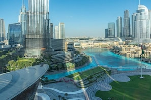 A modern cityscape with prominent skyscrapers, a central water feature, and a distinctive curved building.