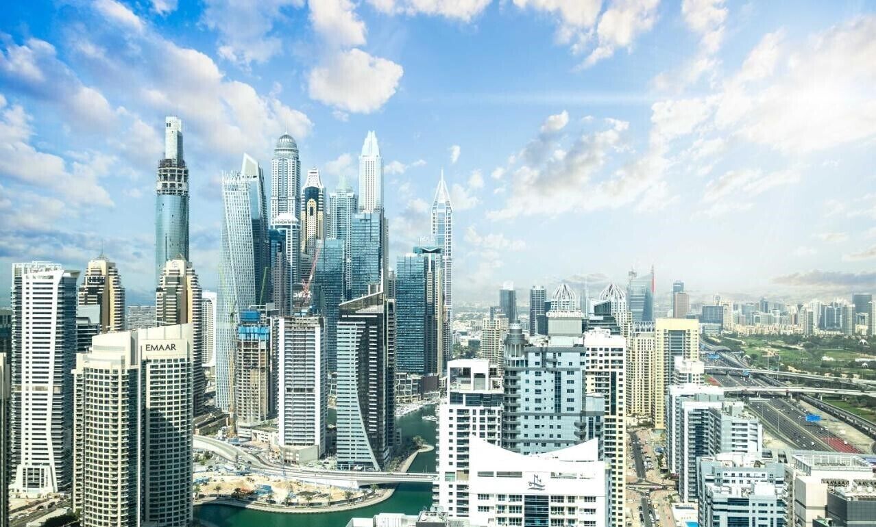 Un paysage urbain avec des gratte-ciel modernes, dont un bâtiment remarquable qui se distingue par son architecture originale.