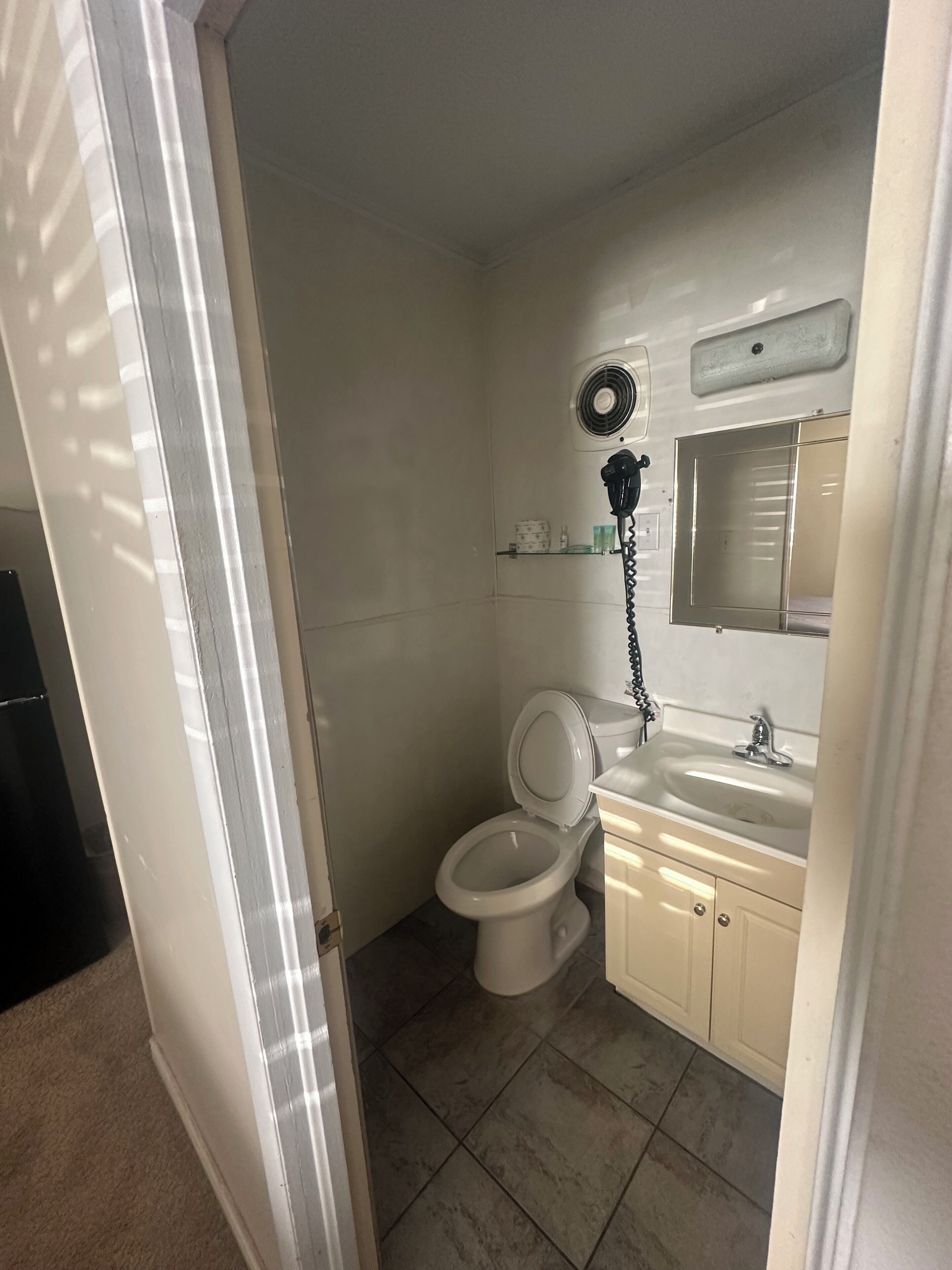 Un baño pequeño y funcional con inodoro, lavabo y espejo.