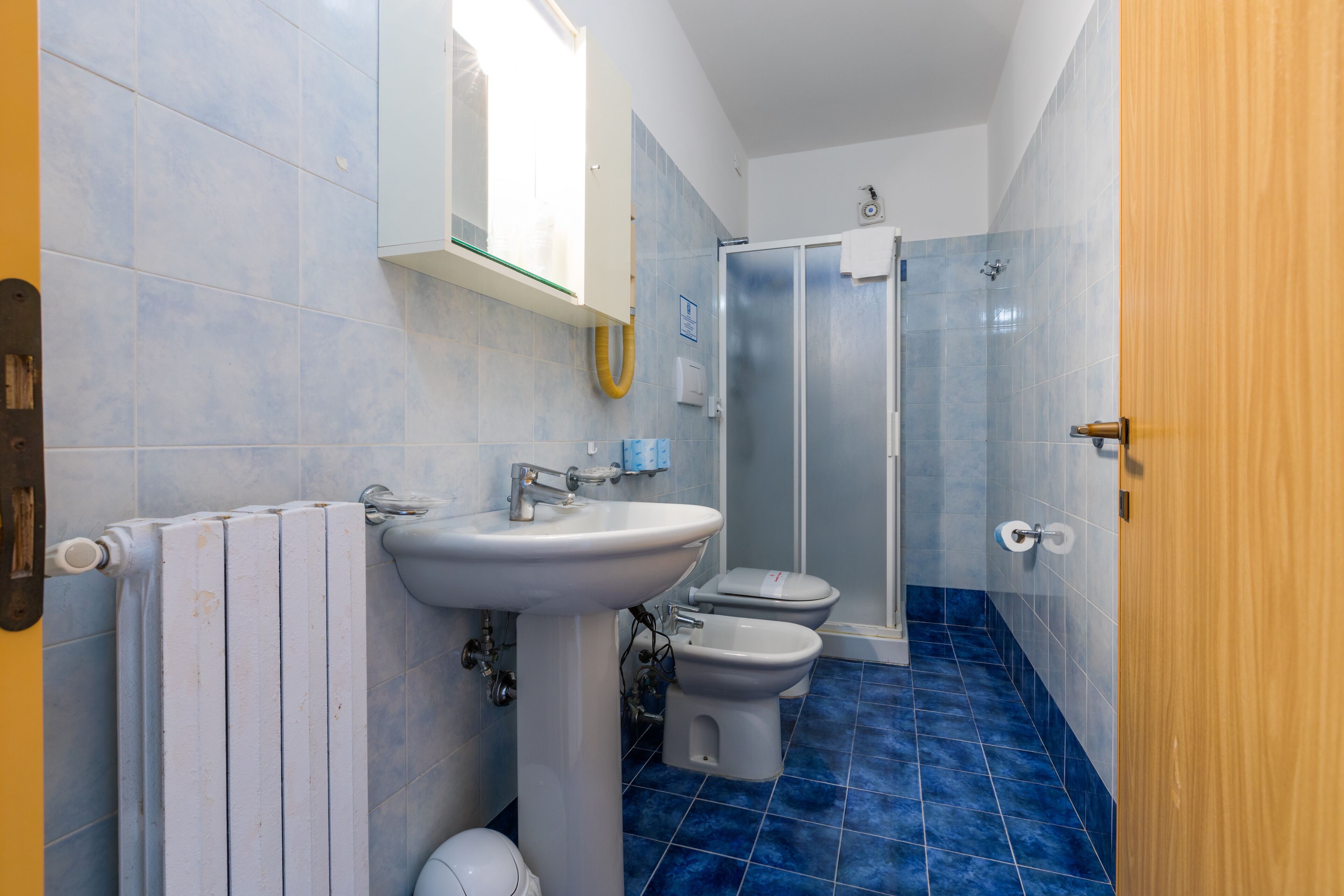 A bathroom with a white sink, toilet, and shower.