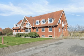 A red-brick building with multiple windows and a sloped roof.