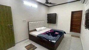 A bedroom with a bed, a wardrobe, a ceiling fan, and a door.