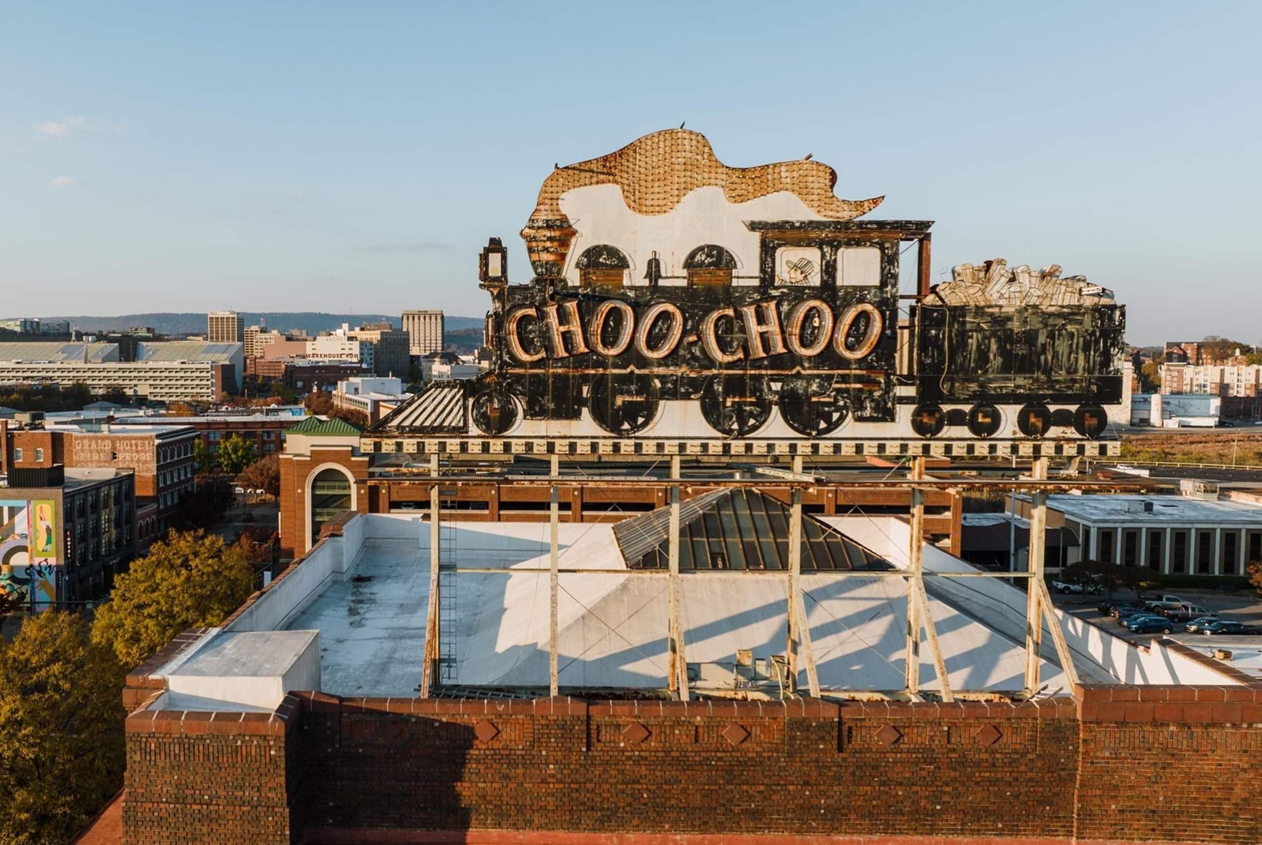 A building with a large sign reading 'CHOO CHOO' and a rooftop with a metal structure.