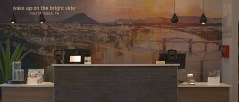 A reception area with a large mural of a cityscape, a reception desk, and pendant lighting.