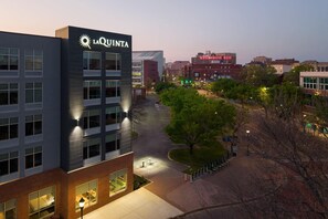 A multi-story building with 'LA QUINTA' signage, a parking lot, and a tree-lined pathway. - La Quinta Inn & Suites by Wyndham Chattanooga Downtown/South (Chattanooga)