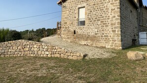 A stone building with a sloped roof, a small window, and a door.