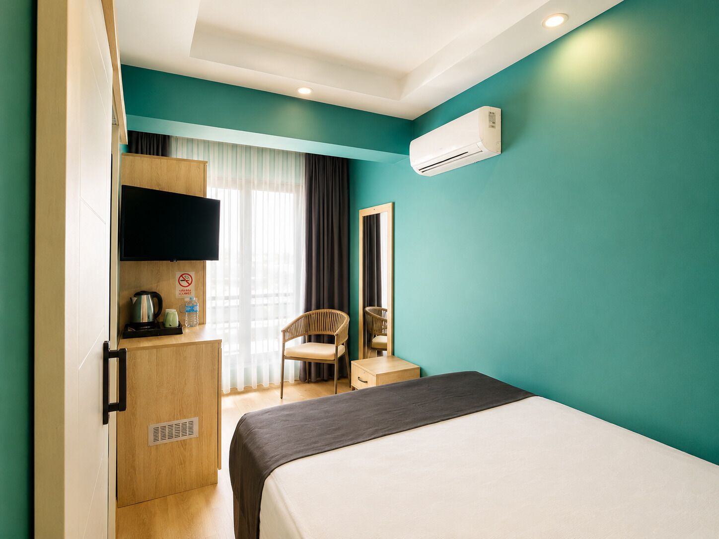 Une chambre d’hôtel comprenant un lit, une télévision, un bureau avec une chaise et une armoire.