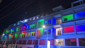 A multi-story building with illuminated windows displaying various colors. - Hotel Grand Brothers (Sylhet)