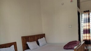 A room with two wooden beds, each with white bedding and a single pillow. - Hotel Grand Brothers (Sylhet)
