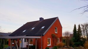 A red brick house with a sloped roof, a covered porch, and a gravel driveway. - fewo1846 - Kranich Museumsberg - apartment with 2 bedrooms on the ground floor (Flensburg)