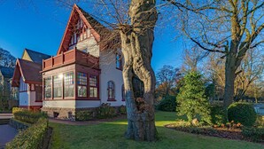 A traditional house with a steep gabled roof, large windows, and a well-maintained lawn. - fewo1846 - Suite Royal - elegant old building apartment with balcony (Flensburg)