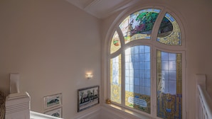A grand staircase with a stained glass window above, framed by white columns and a white balustrade. - fewo1846 - Suite Royal - elegant old building apartment with balcony (Flensburg)