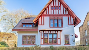 A traditional half-timbered house with a steeply pitched roof, multiple windows, and a visible chimney. - fewo1846 - Villa Royal (Flensburg)