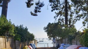 Un camino que lleva a una playa con barcos alineados a los lados.