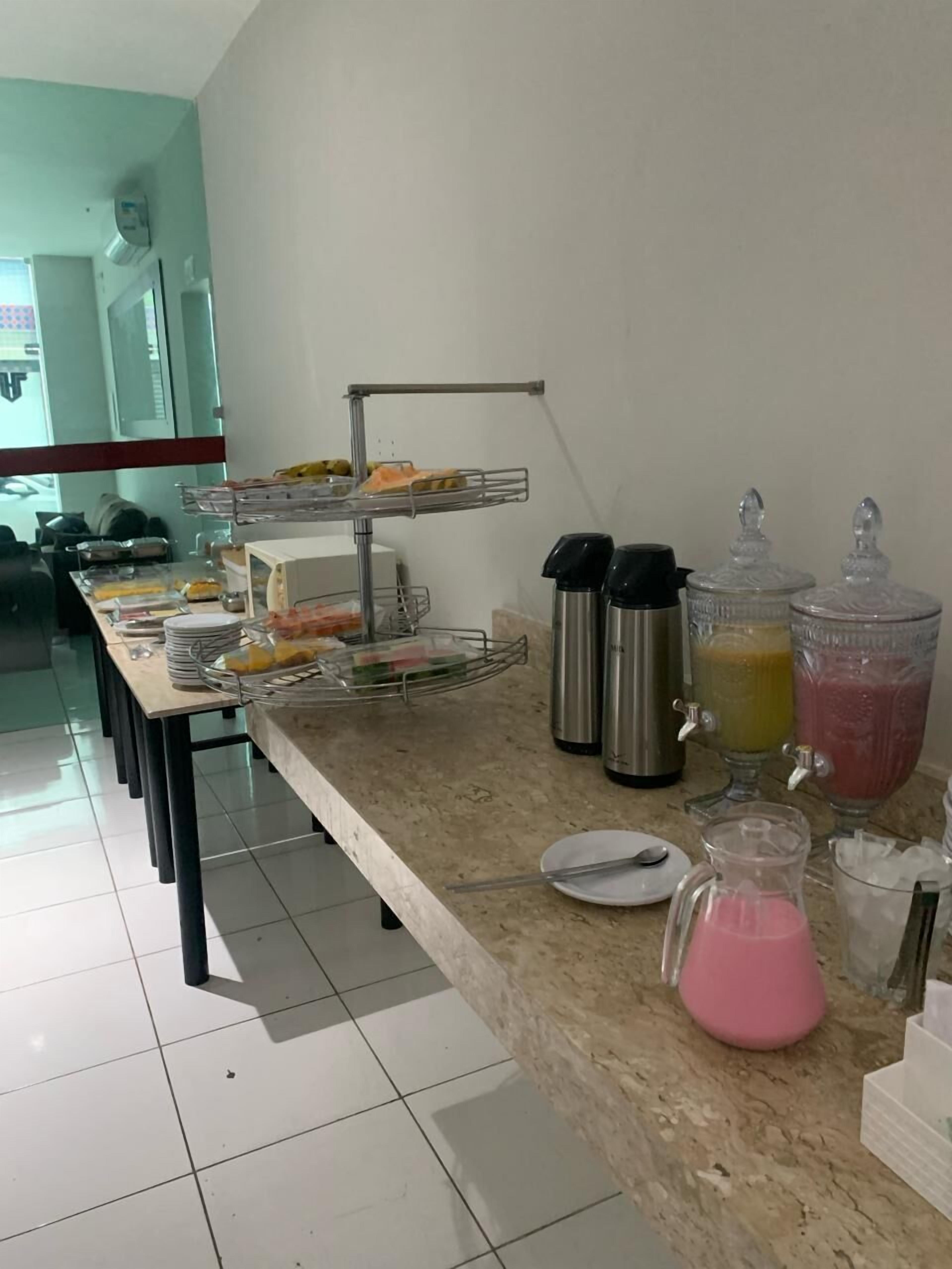 Montaje tipo bufé con fuentes de comida, una máquina de café y dispensadores de bebidas.
