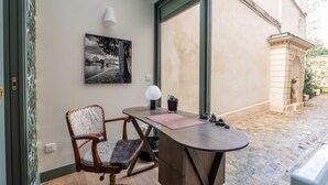A modern room with a curved desk, a chair, a lamp, and a framed photograph on the wall. - A Story in Stone, by Veeve (Paris)
