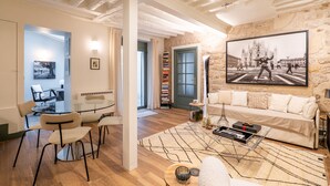 A modern living room with a stone wall, a large framed picture, a sofa, and a coffee table. - A Story in Stone, by Veeve (Paris)