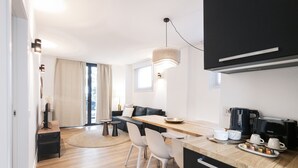 Eine moderne Küche mit einer Holz Arbeitsplatte, weißen Stühlen und einem schwarzen Schrank.