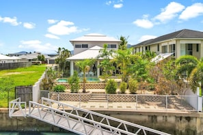 A residential area with houses, a swimming pool, and a bridge.