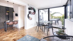Una cocina moderna con comedor, ventanas amplias y vistas al exterior.