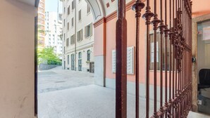 An urban street view with a building entrance featuring a wrought iron gate and a mailbox. - Easylife - Refined apartment in Viale Montegrappa, 18 (Milano)