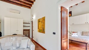 A room with a sofa, a bed, a wooden door, and a painting on the wall. - Easylife - Refined apartment in Viale Montegrappa, 18 (Milano)