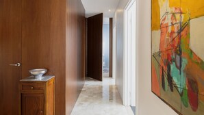 A hallway with a wooden door, a marble countertop, and a colorful abstract painting on the wall. - Easylife - Charming house with terrace (Milano)