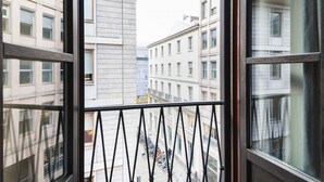 A view from a window with a metal balustrade, overlooking a street with parked bicycles and buildings with multiple stories and windows. - Prestigious apartment Piazza Duomo by Easylife (Milano)
