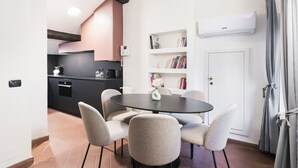 A modern kitchen with a black countertop, a built-in oven, and a white wall-mounted air conditioner. - Prestigious apartment Piazza Duomo by Easylife (Milano)
