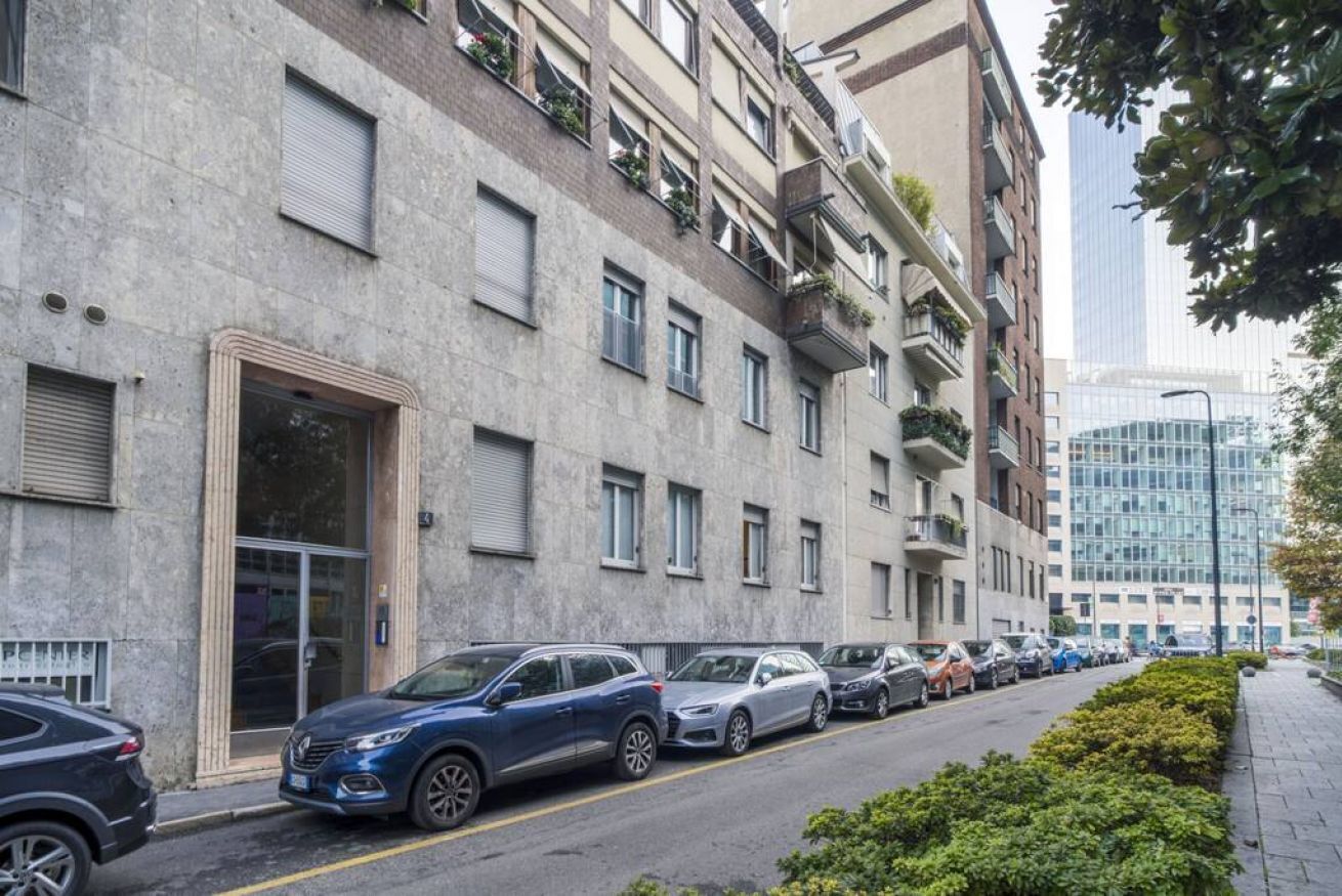 Un immeuble résidentiel à plusieurs étages avec un parking situé à l’avant.