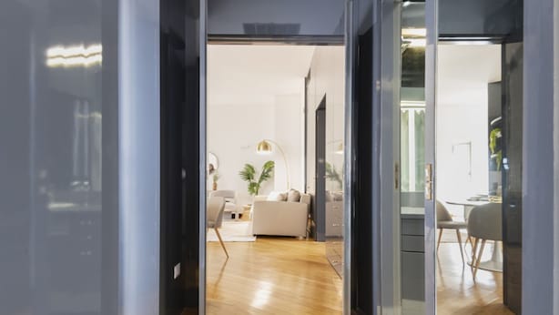 Un intérieur avec un plancher en bois, un canapé, une table à manger et un coin cuisine.