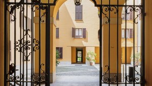 Une courClose agrémentée d’un bâtiment doté de fenêtres en arc de cercle et d’une porte centrale.