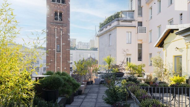A courtyard with potted plants and a brick tower. - Easylife - Amazing studio in San Babila (Milano)