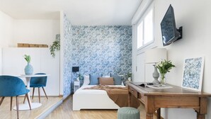 A bedroom with a bed, bedside table, and a desk with a chair. - Easylife - Amazing studio in San Babila (Milano)