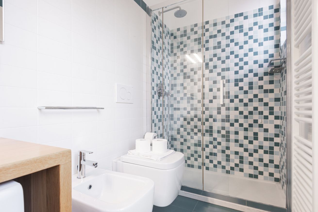 Et moderne badeværelse med bruser, toilet og vask.