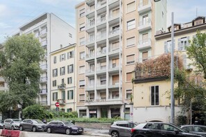 A multi-story residential building with balconies, parked cars, and a no-entry sign. - Easylife - Bright residence in Sant'Ambrogio (Milano)