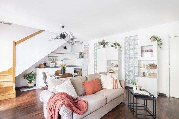 A modern living room with a sofa, a coffee table, and a staircase.