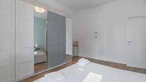 A modern bedroom with a large bed, white wardrobe, and a mirror. - Easylife - Cuddle & relax in the heart of Isola (Milano)