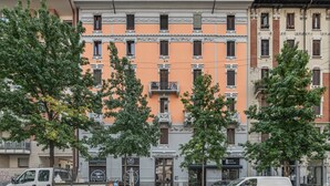 A street view with a building featuring a central entrance, multiple windows, and a balcony. - Easylife - Cuddle & relax in the heart of Isola (Milano)