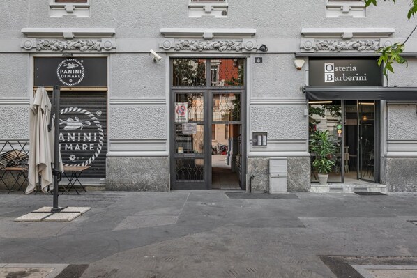 A building with storefronts for 'PANINI DI MARE' and 'Osteria Barberini'.