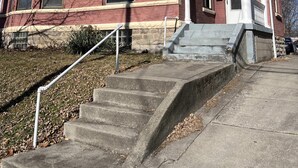 A two-story building with a red brick facade and a beige roof. There is a set of concrete steps leading to a white door with a number "2188" above it. - Cleneay #1, Private 3 Bed near Xavier & Downton (Cincinnati)