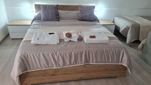 Una cama bien hecha con cabecera de madera, una mesita de noche y una lámpara de noche.