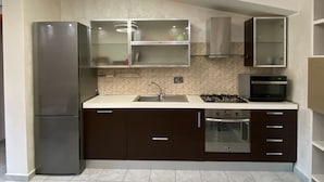 Une cuisine moderne équipée d’un réfrigérateur, d’une cuisinière, d’un four, d’un four à micro-ondes et d’un évier.